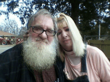 a man with a beard and glasses poses for a picture with a woman