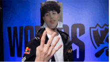 a man wearing a red bull jacket is holding up his hand