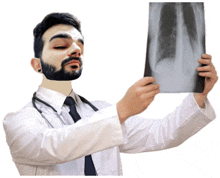 a doctor with a beard is looking at an x-ray of his lungs