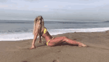 a woman in a yellow bikini is laying on a beach .