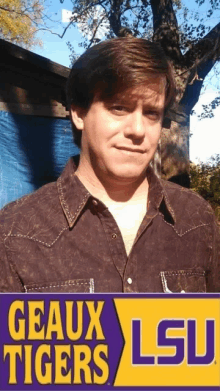 a man standing in front of a sign that says geaux tigers lsu