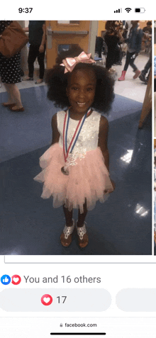 a little girl wearing a pink dress and a medal is on a facebook page