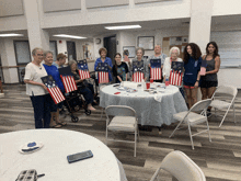 a group of women standing around a table holding flags