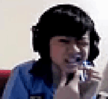 a pixelated image of a woman wearing a blue shirt with the letter t on the front