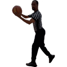 a man in a striped shirt is holding a basketball in his hands