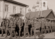 a group of soldiers marching in front of a building