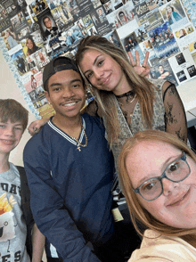 a group of people are posing for a picture in front of a wall that has pictures of graduates from the year 2013