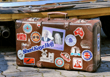 a suitcase with stickers on it including one that says " sherikave hoff "