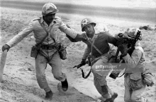 a soldier wearing a helmet with a star on it helps another soldier