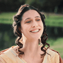 a woman with curly hair and a crown on her head smiles