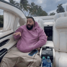 a man is sitting in the back seat of a car .