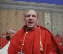 a man in a red robe with a cross on his neck