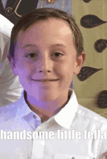 a young boy in a white shirt with the words handsome little fella below him