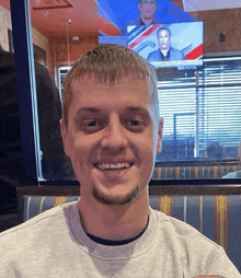 a man is smiling in front of a tv screen that says cbs