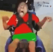 a blurry picture of a person in a wheelchair with a red shirt and green shorts