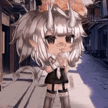 a girl with horns is standing on a sidewalk holding a cup of coffee .