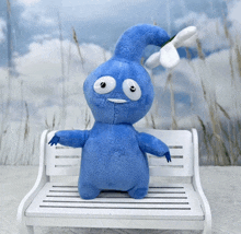 a blue stuffed animal is sitting on a bench