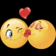 two smiley faces are kissing each other with a red heart between them .