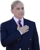 a man wearing a suit and tie holds his hand to his chest