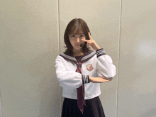 a girl in a school uniform has a badge on her shirt that says ' nmb48 '