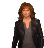 a woman with red hair wearing a black leather jacket and a grey shirt