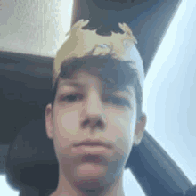 a young boy wearing a paper crown is sitting in a car .