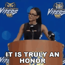 a woman is standing at a podium with the words " it is truly an honor " written on it