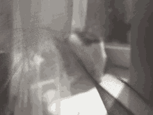 a close up of a white curtain with a blurred image of a person behind it