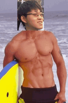 a shirtless man with glasses is holding a surfboard on the beach