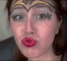 a woman with wonder woman painted on her face is making a funny face