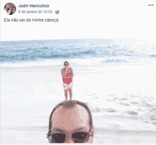 a man and a woman are standing on a beach .