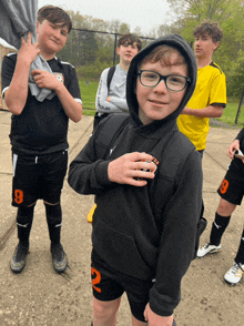 a boy wearing a black hoodie with the number 9 on it