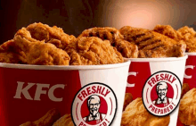 three buckets of kfc fried chicken are lined up in a row