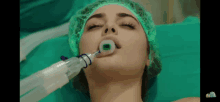 a woman with an oxygen mask in her mouth is laying on a bed