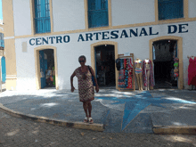 a woman stands in front of a centro artesanal de store