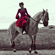 a woman in a red dress is riding on the back of a white horse