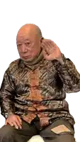 a bald man wearing a shirt with a pattern on it is covering his ears