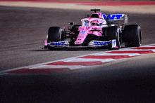 a pink race car is driving down a track with a hyundai logo on the front