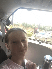 a young girl is sitting in a car with a seat belt on