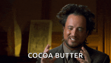 a man in a suit and tie says cocoa butter with his hands