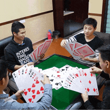 a man wearing a sweatshirt that says interests ting magic jeans playing cards