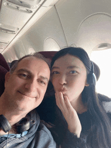 a man and a woman are sitting on an airplane