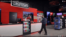 a video of a techtown store with a man walking past the counter