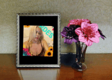 a picture frame with a picture of a woman next to a vase of flowers