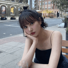 a woman sits on a bench with her hand on her face