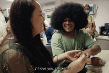 a man with an afro is holding a woman 's hand and says " i love you chicken '