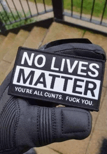 a person holding a patch that says no lives matter