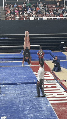 a gymnast is doing a handstand on a mat that says arizona on it