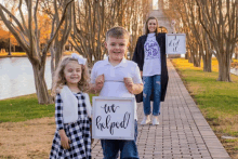 a boy and a girl holding signs that say we helped