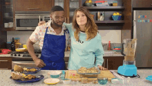 a man and a woman are cooking in a kitchen and the woman is wearing a shirt that says golf